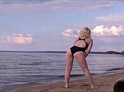 blonde babe charging at sea in costume.