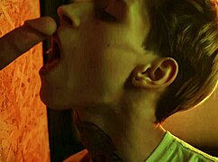 A twink wonders at the glory hole, giving a blowjob to a stranger in the casual setting.