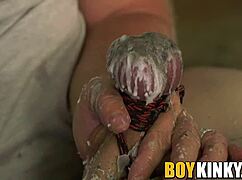 tormented gay guy bound tight, balls waxed, and cock wanked hard in bdsm session