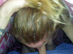 A petite blonde performs a blowjob.