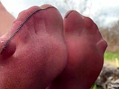 Goddess in spring forest teases with feet in tan pantyhose