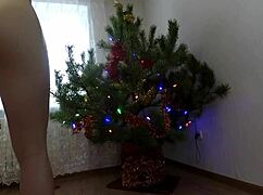 Teen bitch dances naked around the Christmas tree showing tits and ass
