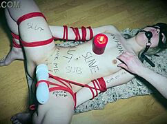 bound slave uses vibrator as a candlestick