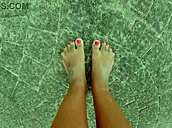 African pornstar walks barefoot on beach and street, dirtying feet.