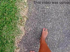 African pornstar walks barefoot on beach and street, dirtying feet.