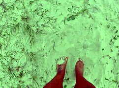 African pornstar walks barefoot on beach and street, dirtying feet.