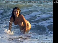naked latina brunette girl bent over on public beach