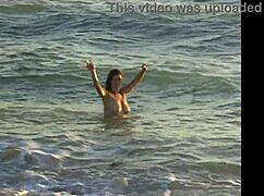 naked latina brunette girl bent over on public beach