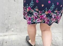 Следую за зрелой на улице в юбке и стрингах