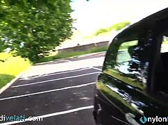 Brunette in black pantyhose shows off her feet from her car