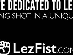 Juicy brunette babe fists her lesbian friend's pussy playfully.