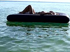 Beautiful blonde girl enjoys nude beach with big boobs and dolphin tattoo in public nudist outdoor setting