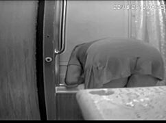 jennifer bent over washing the shower in the bathroom