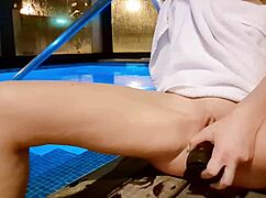 she strokes herself to orgasm by the pool at night