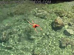 Wet Shaved Pussy Flashes from Yellow Trunks in Blue Beach Water!
