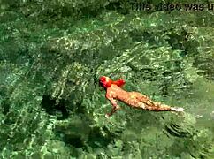 Wet Shaved Pussy Flashes from Yellow Trunks in Blue Beach Water!