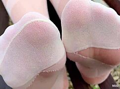 enjoy seductive nylon feet on a bench in white patterned pantyhose